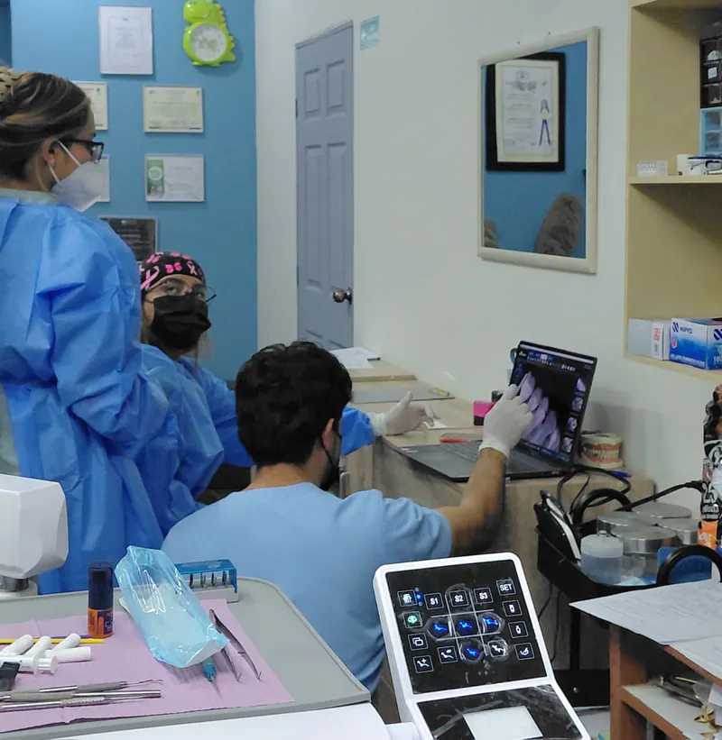 Equipo de Clínica Dental JH revisando imágenes dentales en una computadora